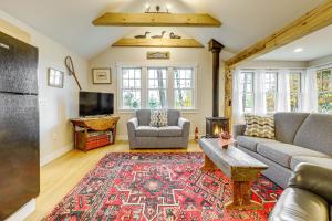 Wild Goose Cottage Near Mt Sunapee Ski Area! في New London: غرفة معيشة مع أريكة وتلفزيون