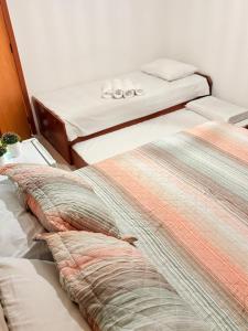 two beds sitting next to each other in a room at Pousada Três Marias - Guaiuba in Guarujá