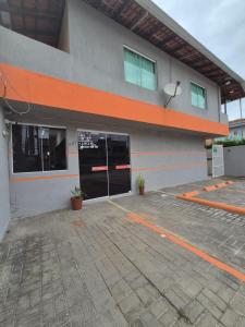 イタポアにあるHotel Recanto das Pedrasの大きなドアと駐車場のある建物 +5枚の写真