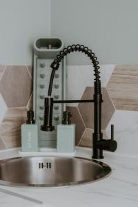 eine Küchenspüle mit einem schwarzen Wasserhahn in der Unterkunft LE CATELE - Studio RIOM - 3 pers - Vulcania - Puy de Dôme - Proche Clermont Ferrand in Riom + 14 Fotos