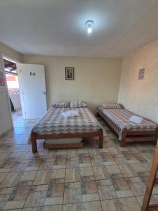 イタポアにあるHotel Recanto das Pedrasのベッド2台とテーブルのある部屋