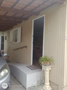 un porche de una casa con una puerta y una planta en Casa próximo ao Aeroporto, en Florianópolis 1 foto más