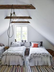 two beds in a attic bedroom with white walls at Harrys Hardware Home in Brösarp