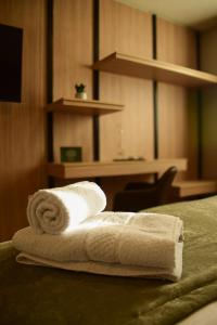 a stack of towels on a bed in a hotel room at Tótem Hotel & Spa in San Martín