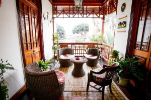 a porch with wicker chairs and a table on a balcony at Lima Wari Hotel Boutique in Lima