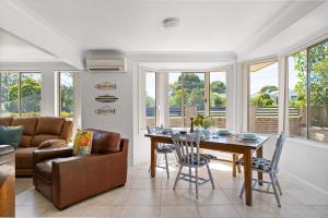 ein Wohnzimmer mit einem Tisch und einem Sofa in der Unterkunft Sunny Days Villa Vincentia in Vincentia