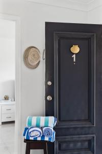eine schwarze Tür in einem Zimmer mit einem Hocker in der Unterkunft Sunny Days Villa Vincentia in Vincentia