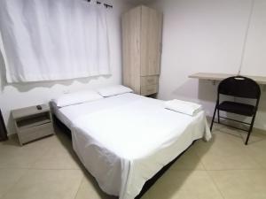 a bedroom with a white bed and a desk at Tu Loft Ideal Amoblado, Wifi, Parqueadero y Confort in Bucaramanga +3 photos