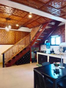 un soggiorno con scala e tavolo con sedie di Oceana a Padre Burgos