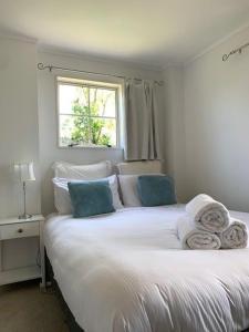 ein Schlafzimmer mit einem weißen Bett mit Handtüchern darauf in der Unterkunft The Garden Room by Waiheke Pure in Waiheke Island