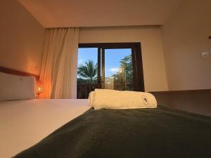 una camera da letto con un letto grande con una finestra di Villa Bougainville 01 - Natú a Mata de Sao Joao