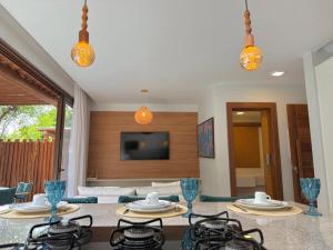 un soggiorno con un tavolo e una tv di Villa Bougainville 01 - Natú a Mata de Sao Joao