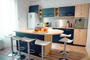 eine Küche mit einer Theke und Hockern darin in der Unterkunft La Tanière du Corsaire - Coliving - jusqu'à 4 chambres - vue Rivière in Redon