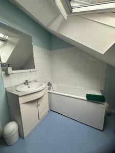 ein Badezimmer mit Waschbecken, Badewanne und Spiegel in der Unterkunft La Tanière du Corsaire - Coliving - jusqu'à 4 chambres - vue Rivière in Redon