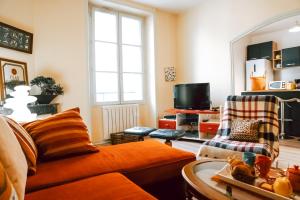 ein Wohnzimmer mit Sofa und Fernseher in der Unterkunft La Tanière du Corsaire - Coliving - jusqu'à 4 chambres - vue Rivière in Redon