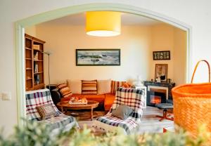 ein Wohnzimmer mit zwei Stühlen und einer Couch in der Unterkunft La Tanière du Corsaire - Coliving - jusqu'à 4 chambres - vue Rivière in Redon + 24 Fotos