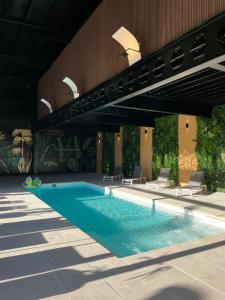 a swimming pool in a building with chairs around it at Tótem Hotel & Spa in San Martín