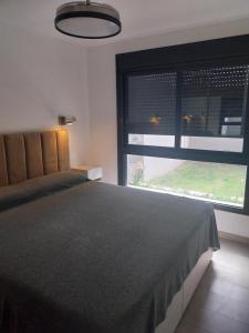 a bedroom with a large bed and a large window at Las Pircas PB in Alta Gracia
