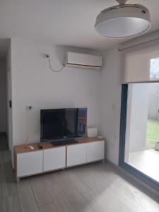 a living room with a flat screen tv on a white wall at Las Pircas PB in Alta Gracia