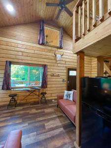 Riverfront, Authentic, Luxury Log Cabin-Bison في واسيلا: غرفة معيشة مع أريكة وتلفزيون بشاشة مسطحة