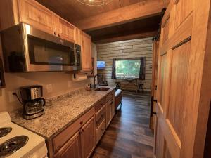 Riverfront, Authentic, Luxury Log Cabin-Bison في واسيلا: مطبخ مع حوض وطاولة عمل