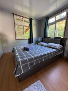Un dormitorio con una cama y dos ventanas. en Villa Blue Lagoon Tahaa, en Tahaa