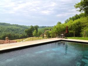einen Pool mit einem Tisch und einem Sonnenschirm in der Unterkunft Maison Milou in Beynac-et-Cazenac + 10 Fotos