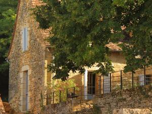 ein Steinhaus mit einem Zaun davor in der Unterkunft Maison Milou in Beynac-et-Cazenac