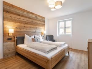 a bedroom with a wooden accent wall and a bed at Hopfgarten Alpin Living Top 3 in Hopfgarten im Brixental