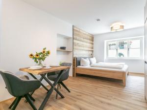 Hopfgarten Alpin Living Top 4 في هوبفغراتن إم بريكسنتال: غرفة نوم بها سرير وطاولة وكراسي