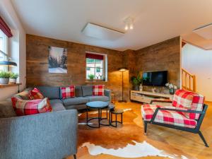 a living room with a couch and a tv at Im grünen Herzen in Donnersbachwald