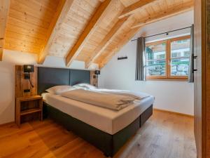 a large bed in a room with wooden ceilings at Im grünen Herzen in Donnersbachwald