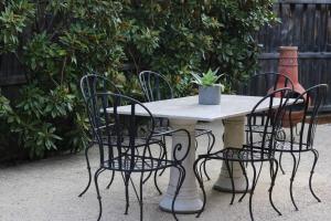 a table with four chairs and a potted plant on it at Senja in Torquay