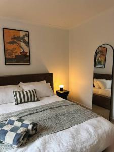 a bedroom with a bed and two mirrors on the wall at Senja in Torquay