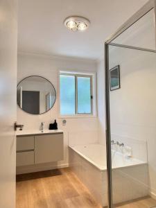 a bathroom with a tub and a sink and a mirror at Senja in Torquay +22 photos