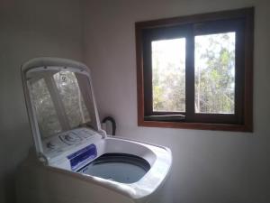 um espelho numa casa de banho com uma janela em Espaço Gaia em Palmeiras