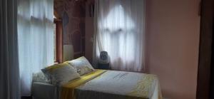 uma cama em um quarto com uma janela e uma cama sidx sidx sidx em Espaço Gaia em Palmeiras