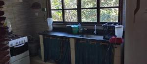 um balcão de cozinha com uma pia e uma janela em Espaço Gaia em Palmeiras mais 28 fotografias