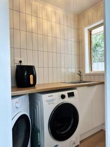a kitchen with a washer and dryer under a counter at Senja in Torquay