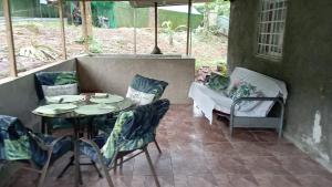a patio with a table and chairs and a couch at Ecotropicfarmhouse in Cerro Azul +14 photos