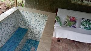 a room with a bed with a tiled floor at Ecotropicfarmhouse in Cerro Azul