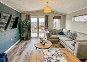 una sala de estar con un sofá y una mesa en Croft Farm Water Park, en Tewkesbury