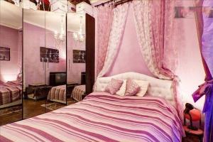 a bedroom with a bed with pink walls and curtains at Romantic & Artistic Apartment in Milan