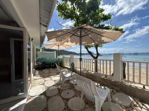 a patio with two white chairs and an umbrella at El Nido, Corong Corong Pier in El Nido