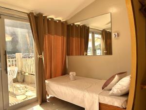 a bedroom with a bed with a mirror and a balcony at El Nido, Corong Corong Pier in El Nido