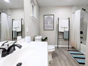 een witte badkamer met een toilet en een wastafel bij Private Master Bedroom North Lamar in Austin
