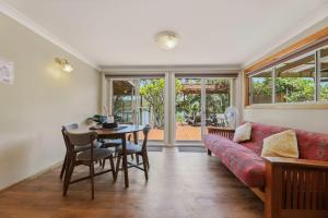 un salon avec un canapé rouge et une table dans l'établissement Dorathee Cottage - Pet Friendly - Absolute Waterfront, à Gunderman