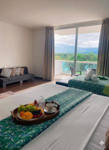 a tray of fruit on a bed in a hotel room at Luz de Laguna in Playa Blanca