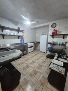 イタポアにあるHotel Recanto das Pedrasのタイルフロアのキッチン(白い冷蔵庫付)