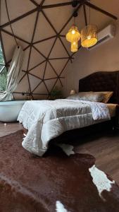 a bedroom with a bed and a tub and chandeliers at Cabana winchesters - Domo in Cascavel
